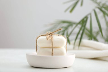 Beyaz masadaki sabun çubukları gri arkaplana karşı, yakın plan