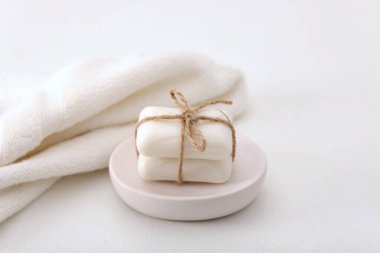 Beyaz masadaki sabun çubukları ve havlular, yakın plan.