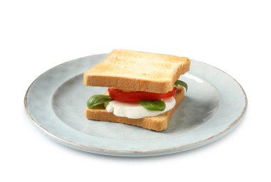 Beyaz arka planda mozarella peynirli, domatesli ve fesleğenli lezzetli sandviç.