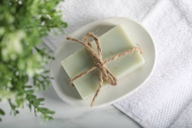 Sabun barı, havlu ve çiçek dekoru beyaz mermer masa, üst görünüm