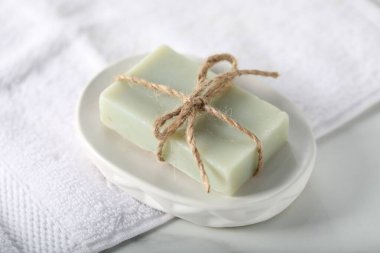 Sabun çubuğu ve havlu beyaz mermer masada, yakın plan.