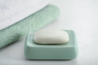 Sabun çubuğu ve havlular beyaz masada, yakın plan.