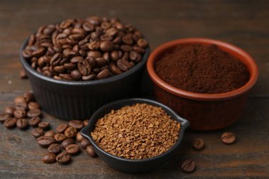 Farklı tipte kahve ve fasulyeler ahşap masada, yakın plan.