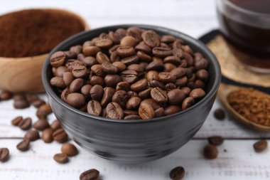 Kavrulmuş fasulye ve beyaz ahşap masada değişik türde hazır kahve.