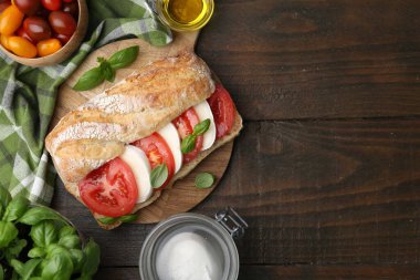 Peynirli, domatesli, ahşap masadaki fesleğenli lezzetli sandviç. Metin için boşluk