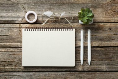 Düz kompozisyon, tahta masanın üzerinde boş bir defter.