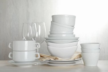 İçerideki açık ahşap masada farklı temiz bulaşık takımı.