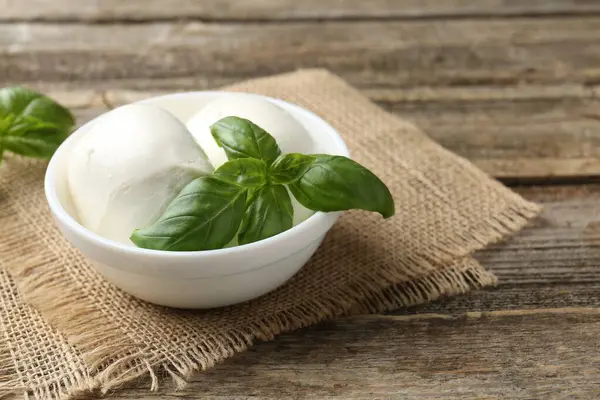 Ahşap masada mozzarella peyniri ve fesleğen, yakın plan. Metin için boşluk