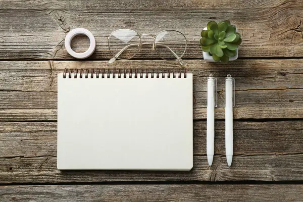 Düz kompozisyon, tahta masanın üzerinde boş bir defter.