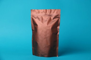 Açık mavi arka planda fermuarlı bir stand-up kesesi. Tasarım için model