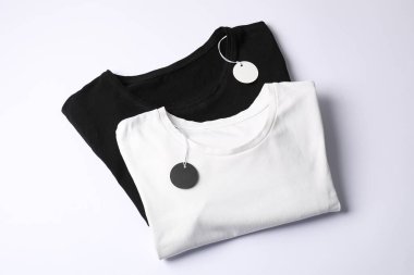 Beyaz arkaplanda etiketli tişörtler, üst görünüm