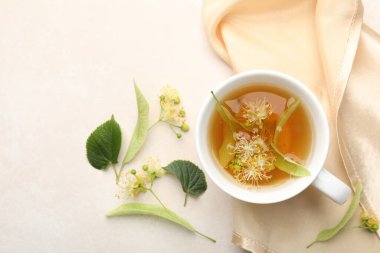 Taze ıhlamur çayı fincanda, çiçekler beyaz masada, düz yerde. Metin için boşluk