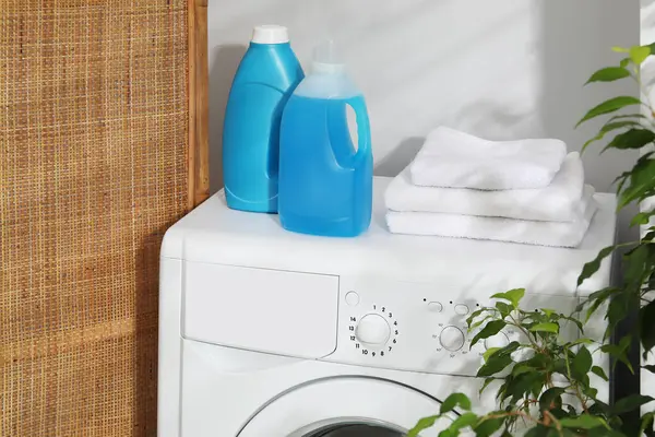 İçerideki çamaşır makinesinde yumuşatıcı ve havlu şişeleri.