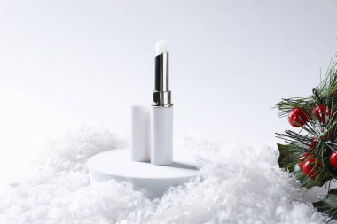 Nemlendirici dudak kremi ve yapay kar üzerine Noel süsü. Kış bakımı