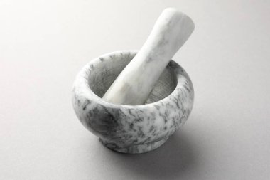 Açık gri arkaplanda mermer harç ve tokmak, yakın plan