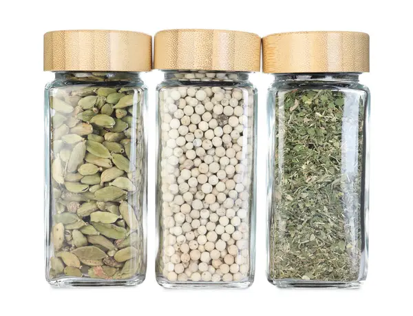 Beyaz kavanozlardaki farklı aromatik baharatlar.