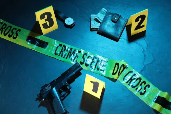 Adli tıp uzmanlığı. Deliller, işaretler ve mavi arka planda polis bandı olan bir suç mahalli. Renkli tonlama efekti