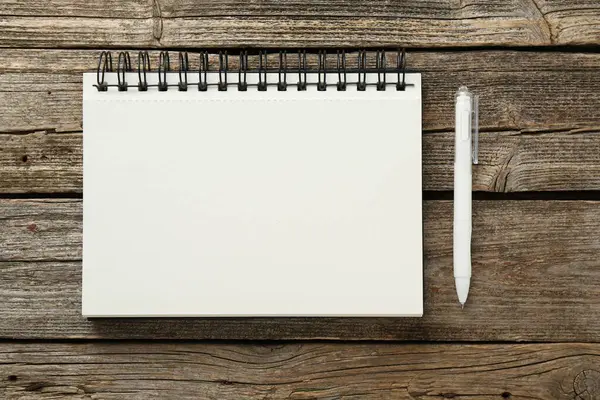 Defter ve kalem ahşap masada, düz yatıyordu.