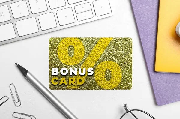 Beyaz masada şık tasarımı, kırtasiyesi ve bilgisayar klavyesi olan bonus kart, düz konum