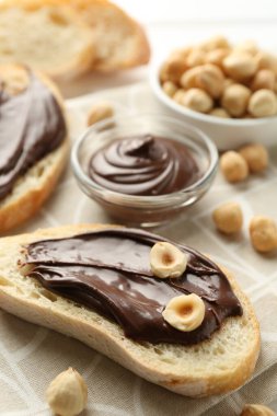 Çikolatalı ekmek dilimleri ve masada fındıklar, yakın plan.