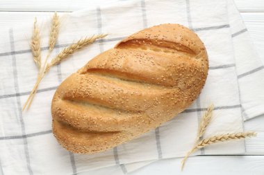 Taze ekmek somunu ve çiviler beyaz ahşap masa üzerinde, düz yatıyordu.