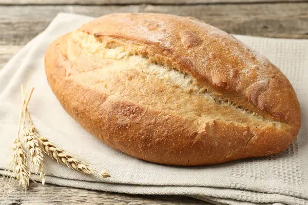 Bir somun ekmek ve çiviler ahşap masada, yakın plan.