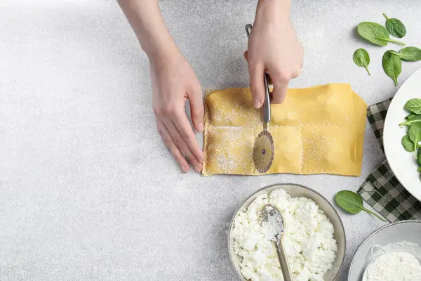 Işık masasında ravioli kesen bir kadın. Metin için boşluk