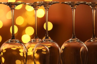 Bulanık ışıklara karşı birçok temiz bardak, yakın plan. Bokeh etkisi