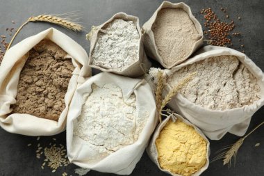 Gri masadaki poşetlerdeki farklı un türleri, düz yatıyordu.