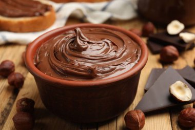 Lezzetli fındık ezmesi, çikolata parçaları ve fındıklar ahşap masada, yakın plan.