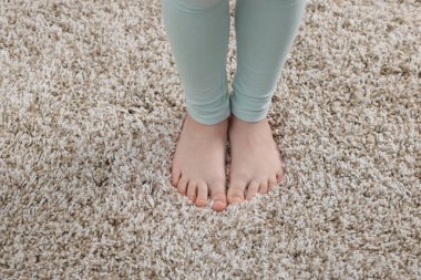 Evdeki yumuşak halıdaki kız, manzaranın üstünde.