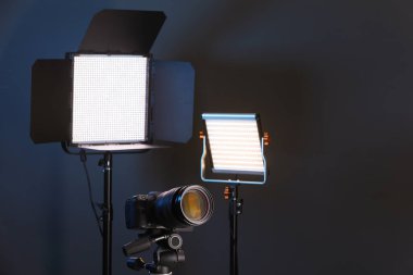 Profesyonel ışıklandırma ekipmanı ve renkli arka planda kamera. Metin için boşluk