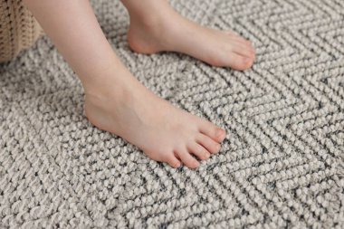 Evdeki gri halıdaki kız, yakın plan.