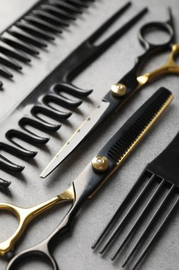 Gri masadaki farklı kuaför aletleri, yakın plan.