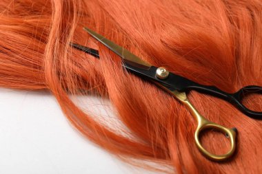 Hafif arkaplanda saç teli ve makas, yakın plan.