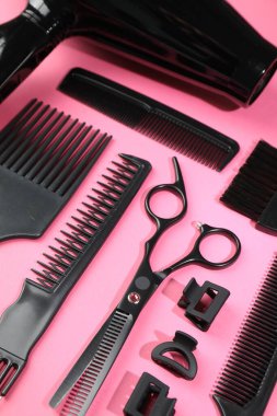 Pembe arka planda farklı kuaför aletleri.