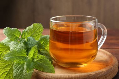 Cam bardakta Aromatik limon merhemi çayı ve masada taze yapraklar, yakın plan.