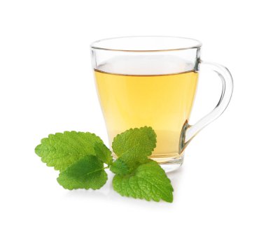 Cam bardakta Aromatik limon merhemi çayı ve beyaz bardakta taze yapraklar.