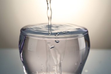 Gri gradyan arkaplanda cama su dökülüyor, yakın plan