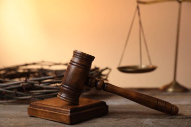 Hakimin tokmağı, dikenli taç ve ahşap masa üzerinde soluk turuncu eğimli arka plan, yakın çekim