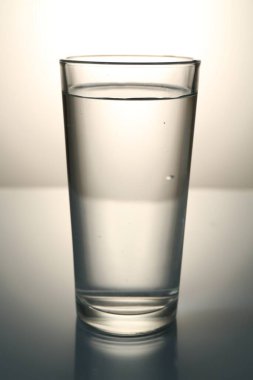 Gri gradyan arkaplana karşı ayna masasında taze su