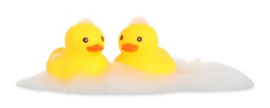 Şirin plastik ördekler ve köpükler beyaz üzerine izole edilmiş.