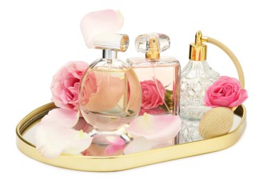 Birçok farklı parfüm şişeleri ve güller beyaz üzerine izole edilmiş.