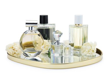 Birçok farklı parfüm şişeleri ve çiçekler beyaz üzerine izole edilmiş.