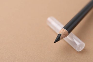 Bej arka planda siyah kaş kalemi, yakın plan. Metin için boşluk