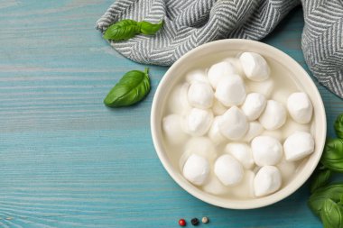 Mavi ahşap masada fesleğenli ve biberli Mozzarella peyniri topları. Metin için boşluk