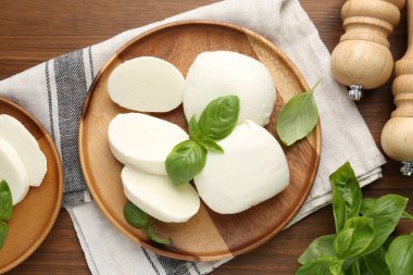 Lezzetli mozarella peyniri parçaları, fesleğen yaprakları ve sallanan ahşap masa, düz yatıyordu.