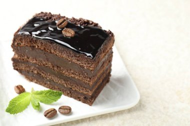 Beyaz masada naneli çikolatalı kek servis ediliyor, yakın plan. Metin için boşluk