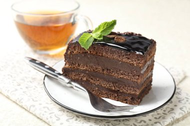 Nane, çatal ve çayla servis edilen çikolatalı kek, yakın plan.