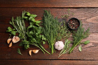 Farklı taze otlar ve baharatlar ahşap masada, düz yatıyordu.